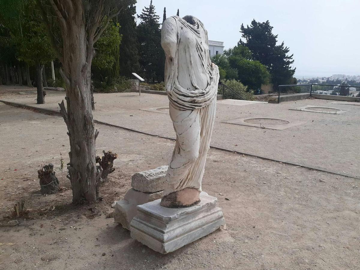 a statue of a woman standing next to a tree