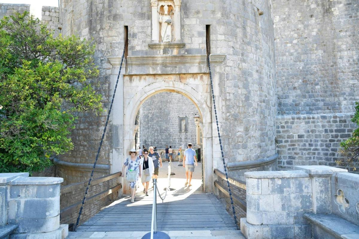 un gruppo di persone che camminano attraverso un arco in un castello