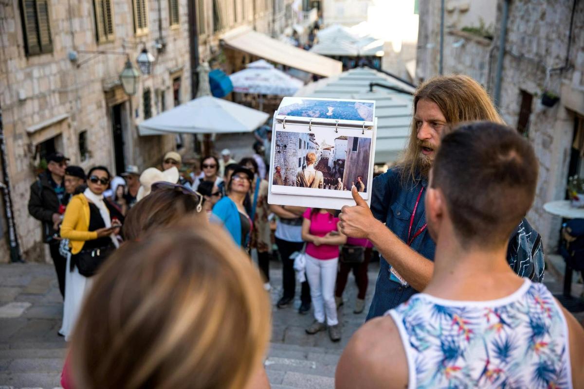 un uomo che tiene in mano un'immagine in mezzo a una folla di persone