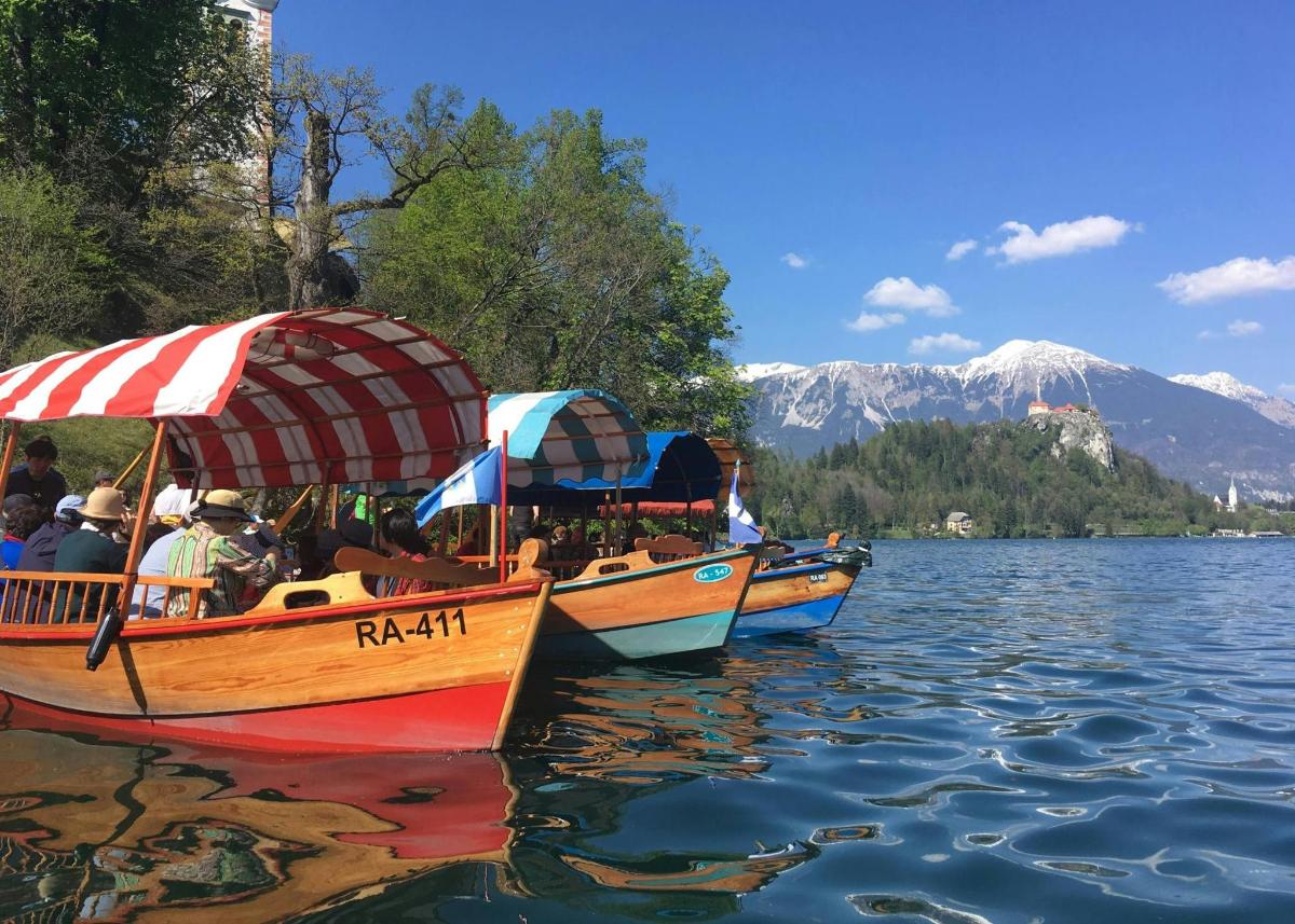tre barche con ombrelloni su un lago con montagne