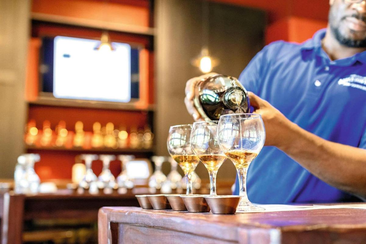 a man pouring champagne into glasses at a bar