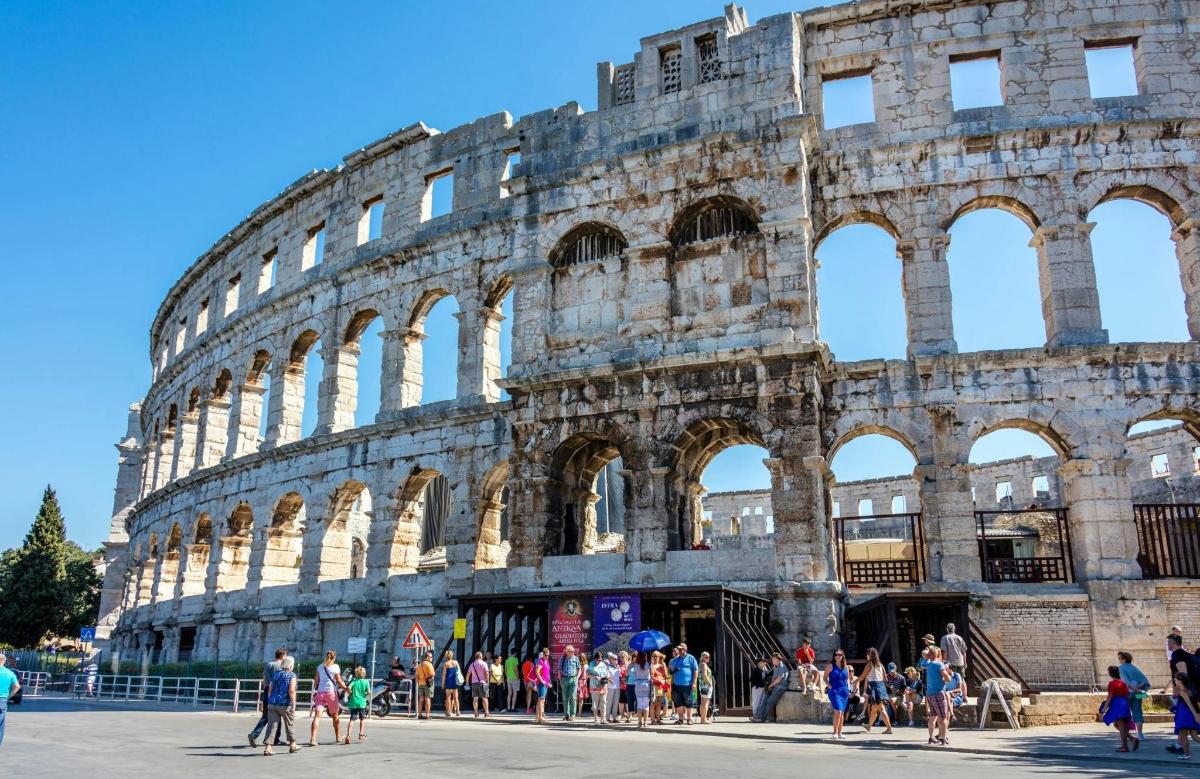 a group of people standing in front of the coliseum