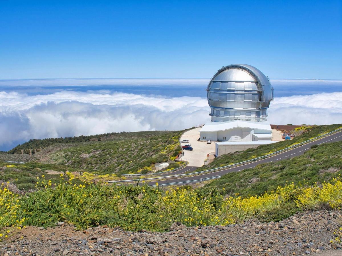 an observatory on top of a hill with clouds