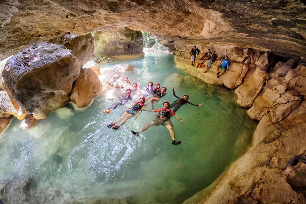 un gruppo di persone che nuotano in un fiume in una grotta