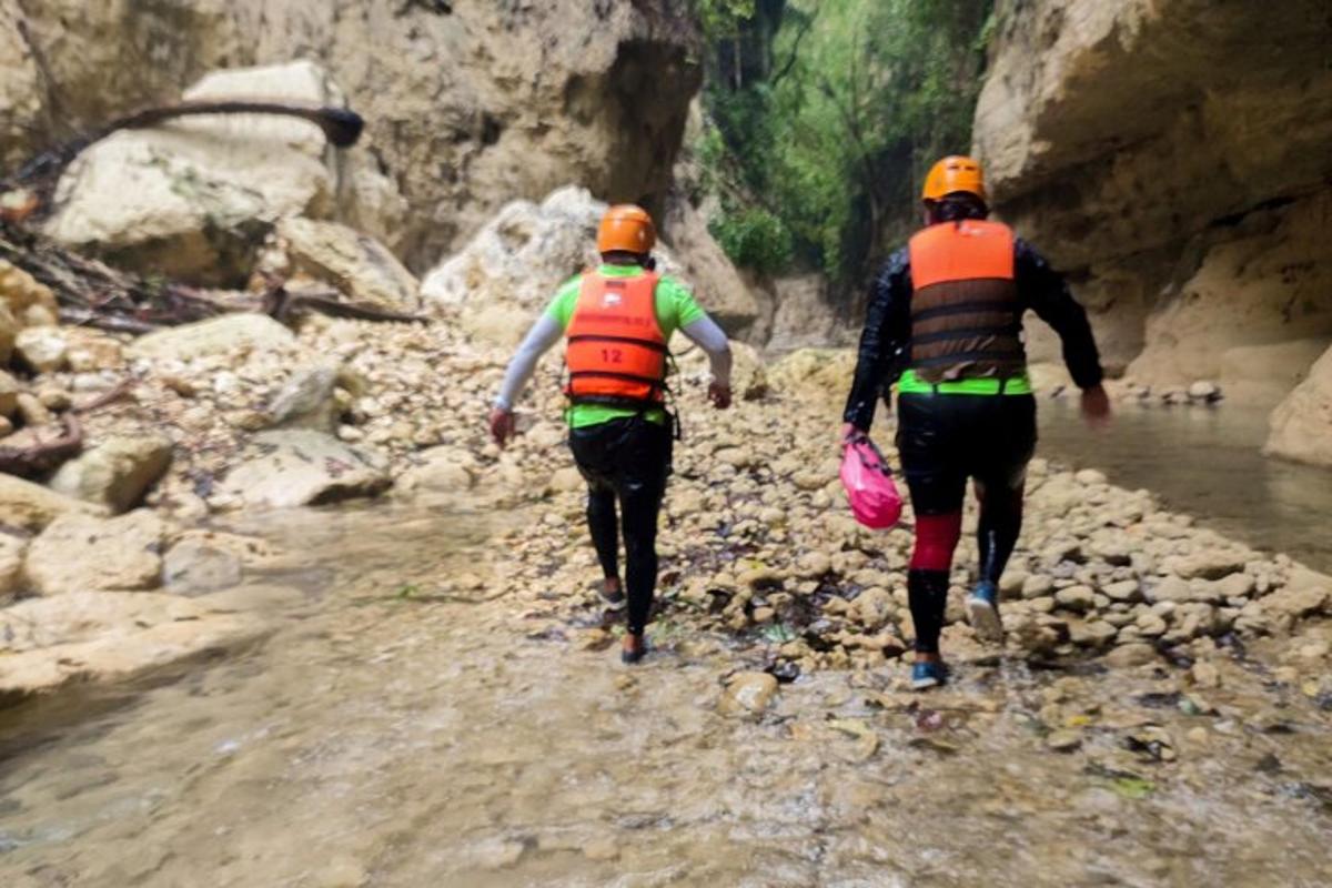 due persone che camminano lungo un sentiero roccioso nell'acqua