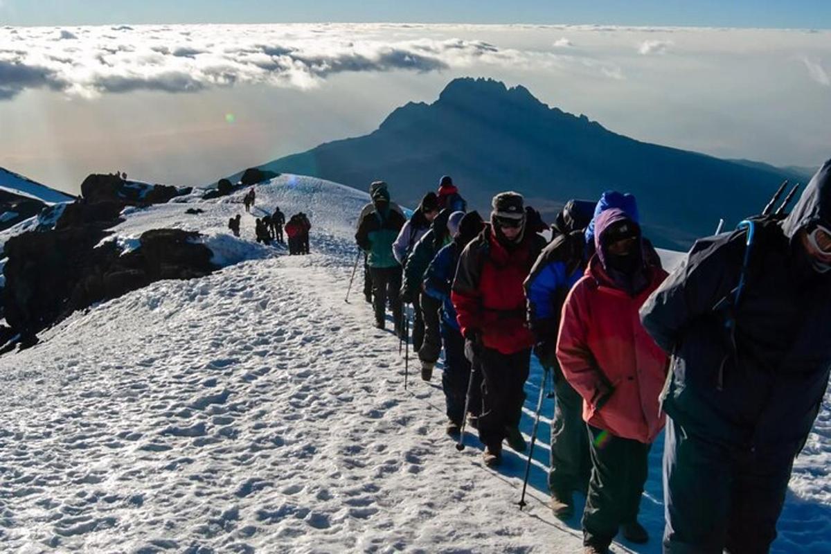 en gruppe mennesker som går opp et snødekt fjell