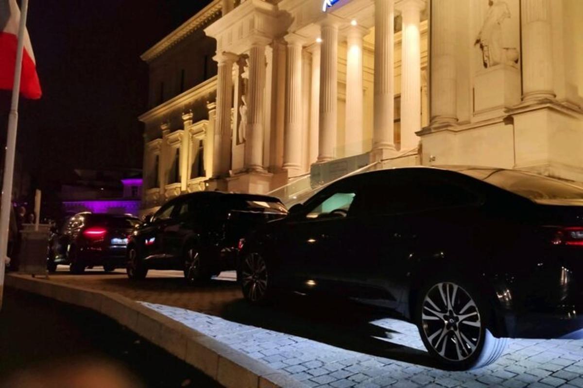 dua buah kereta diletakkan di hadapan sebuah bangunan pada waktu malam