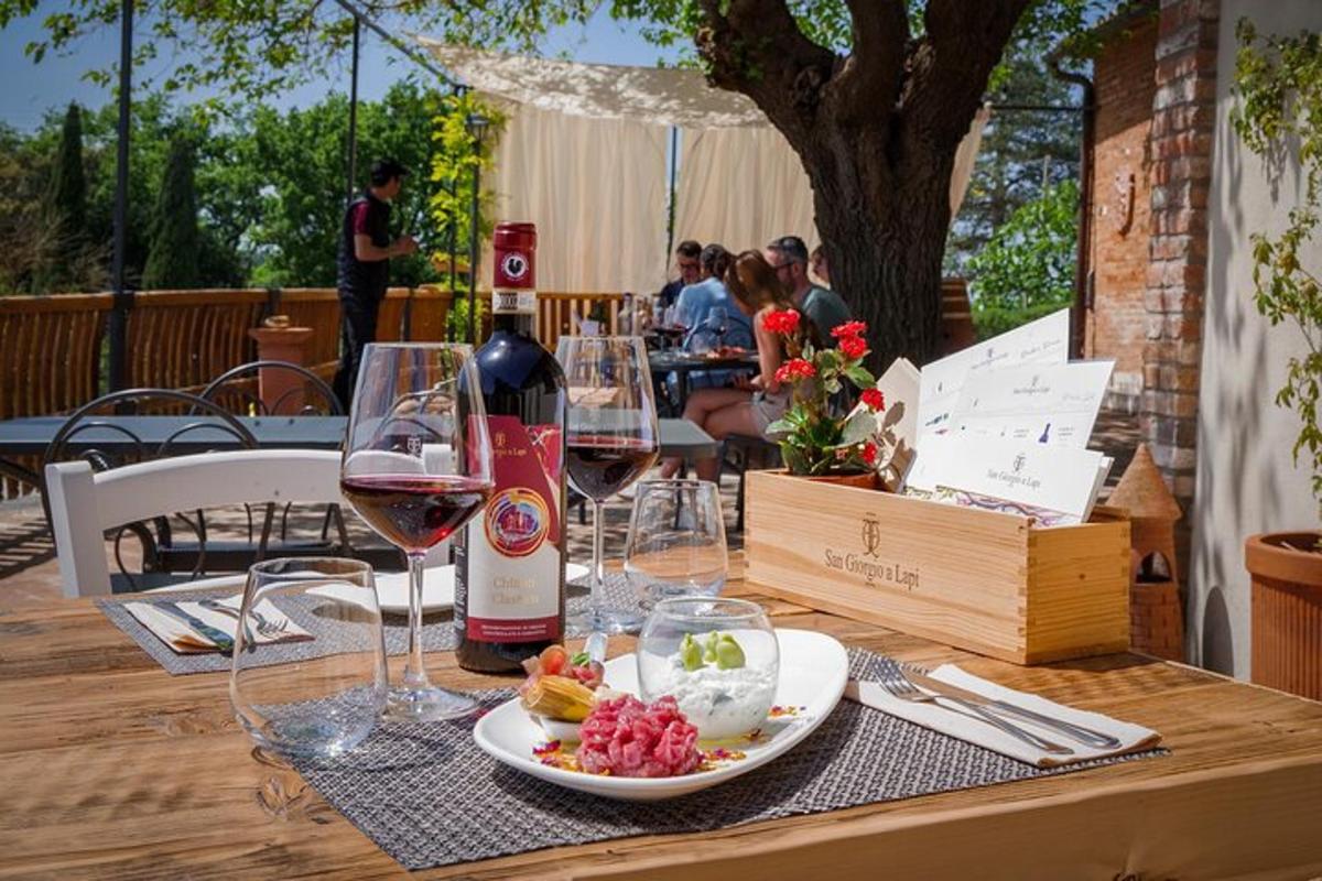 un tavolo con bicchieri di vino e un piatto di cibo