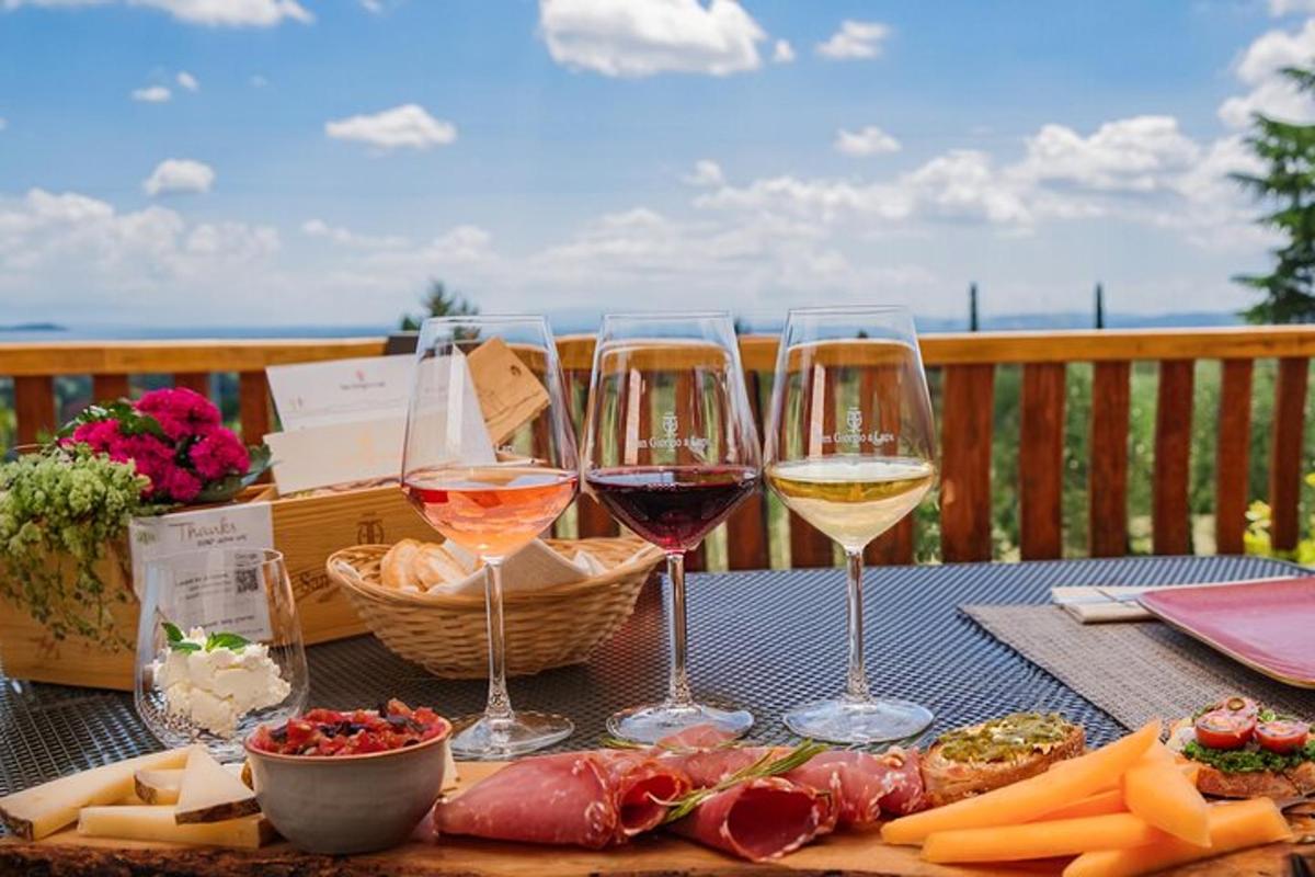 un tavolo con tre bicchieri di vino e formaggio
