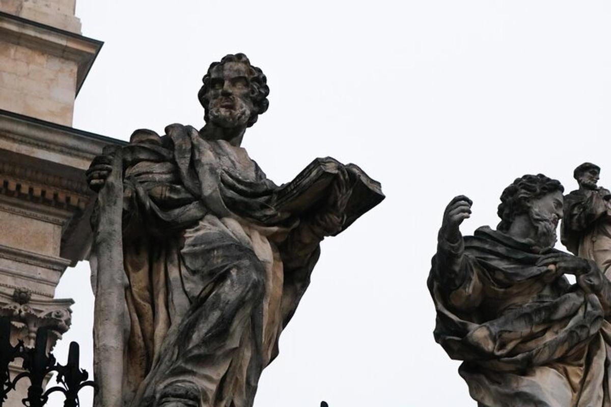 Una estatua de un hombre y una mujer en el costado de un edificio.