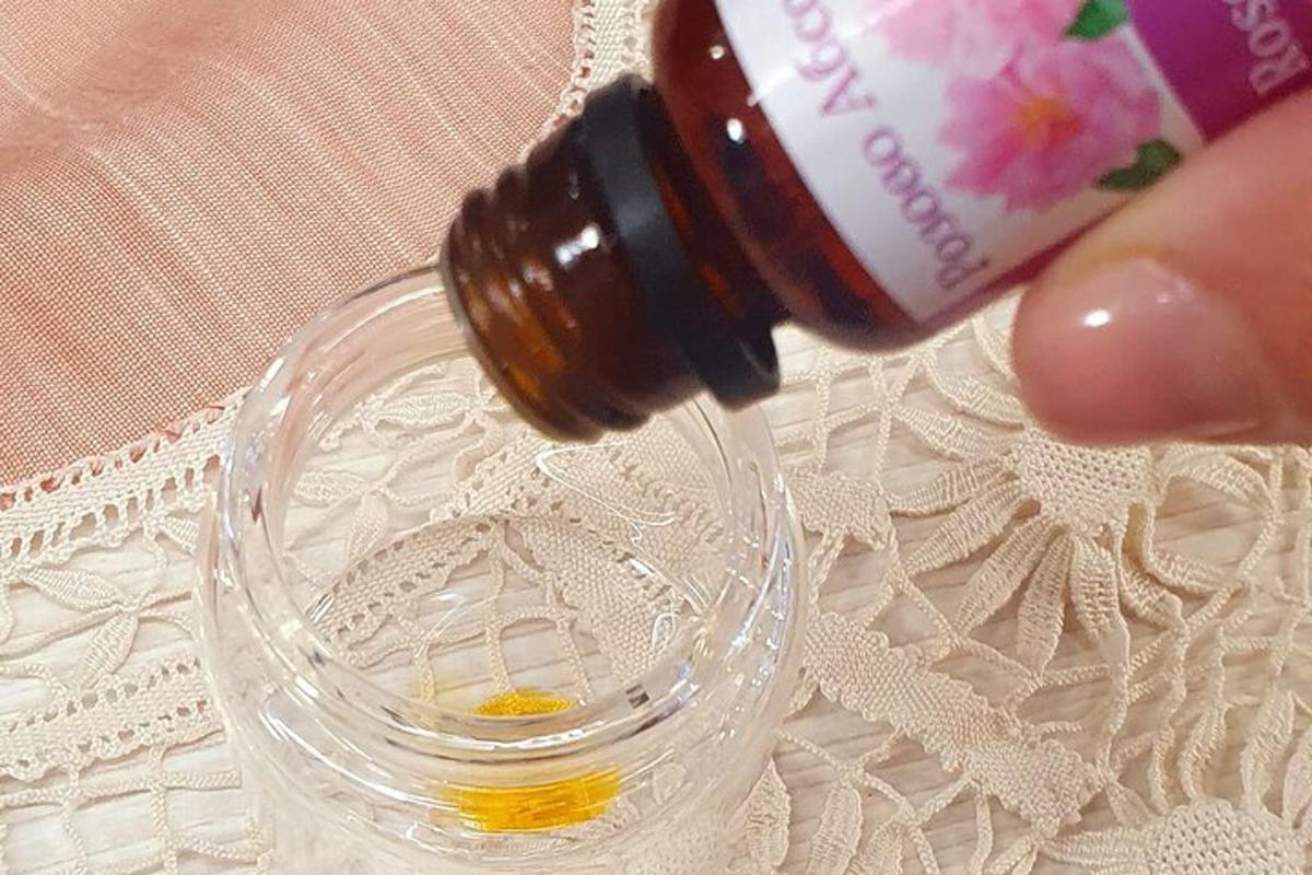 a bottle of essential oils being poured into a glass