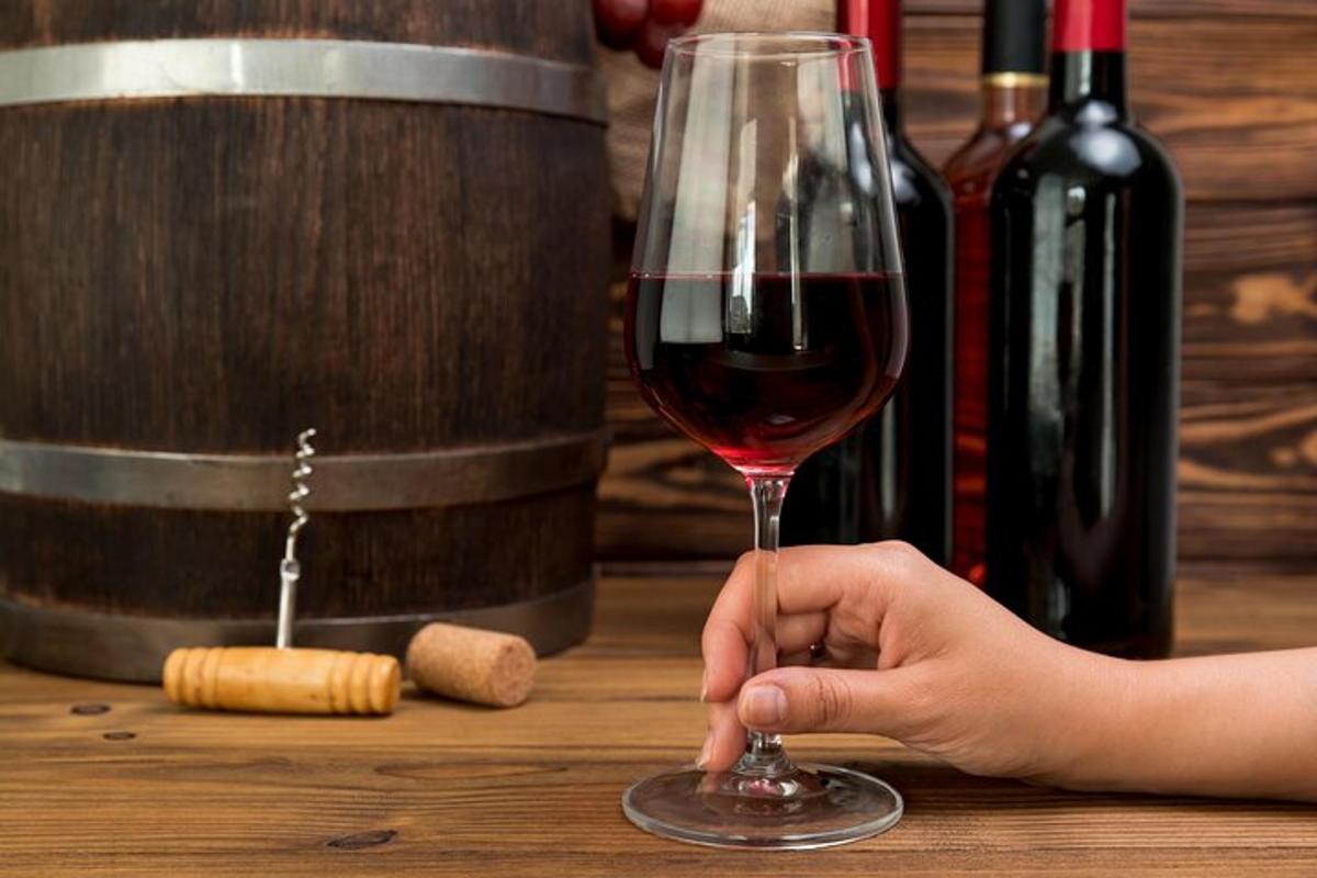 a person holding a glass of wine on a table
