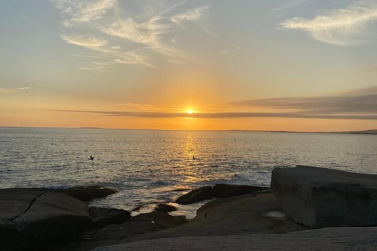a sunset over a body of water with rocks