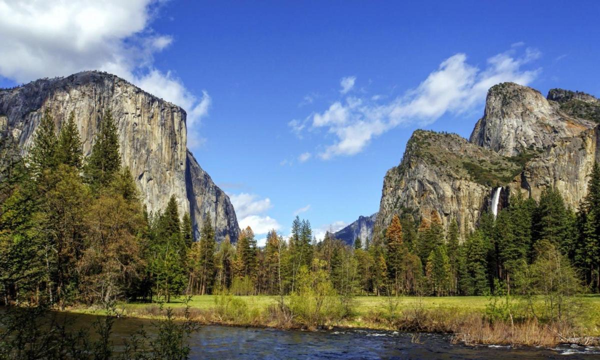 a view of a mountain with a river and trees