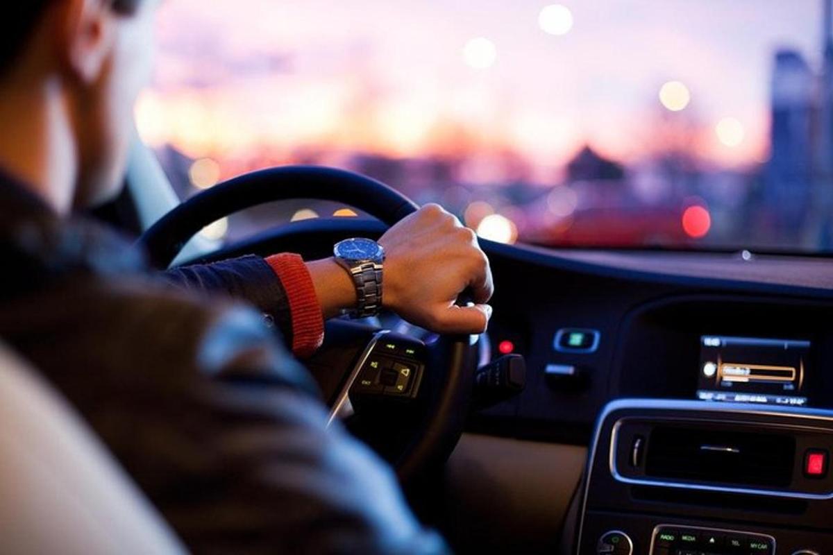 một người lái xe với tay trên vô lăng