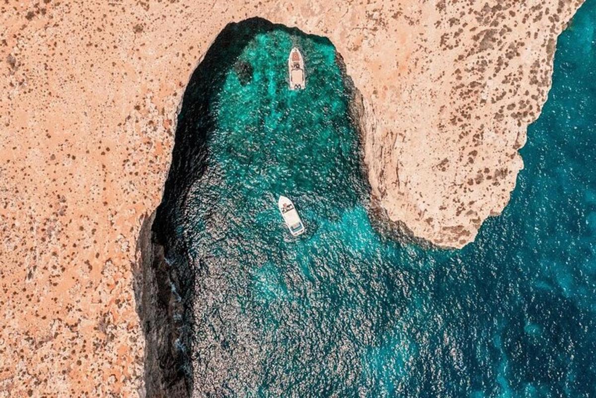 an aerial view of the ocean with a boat