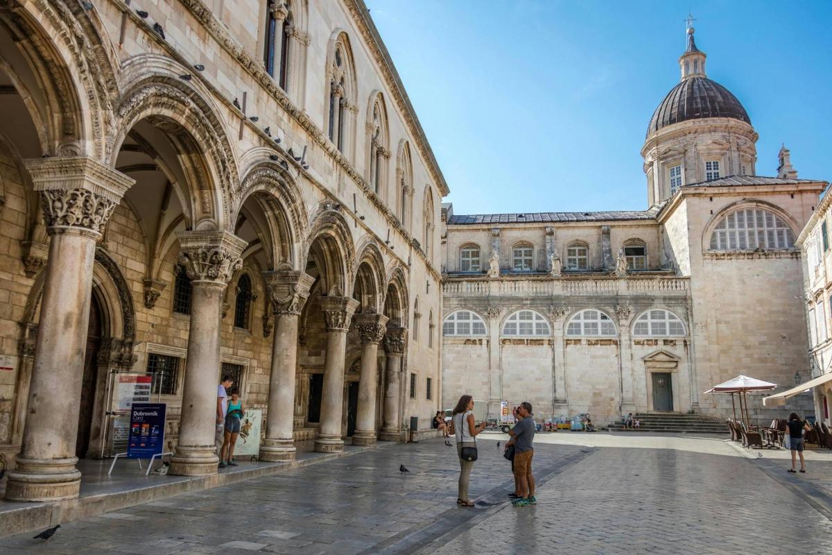 un gruppo di persone in piedi davanti a un grande edificio