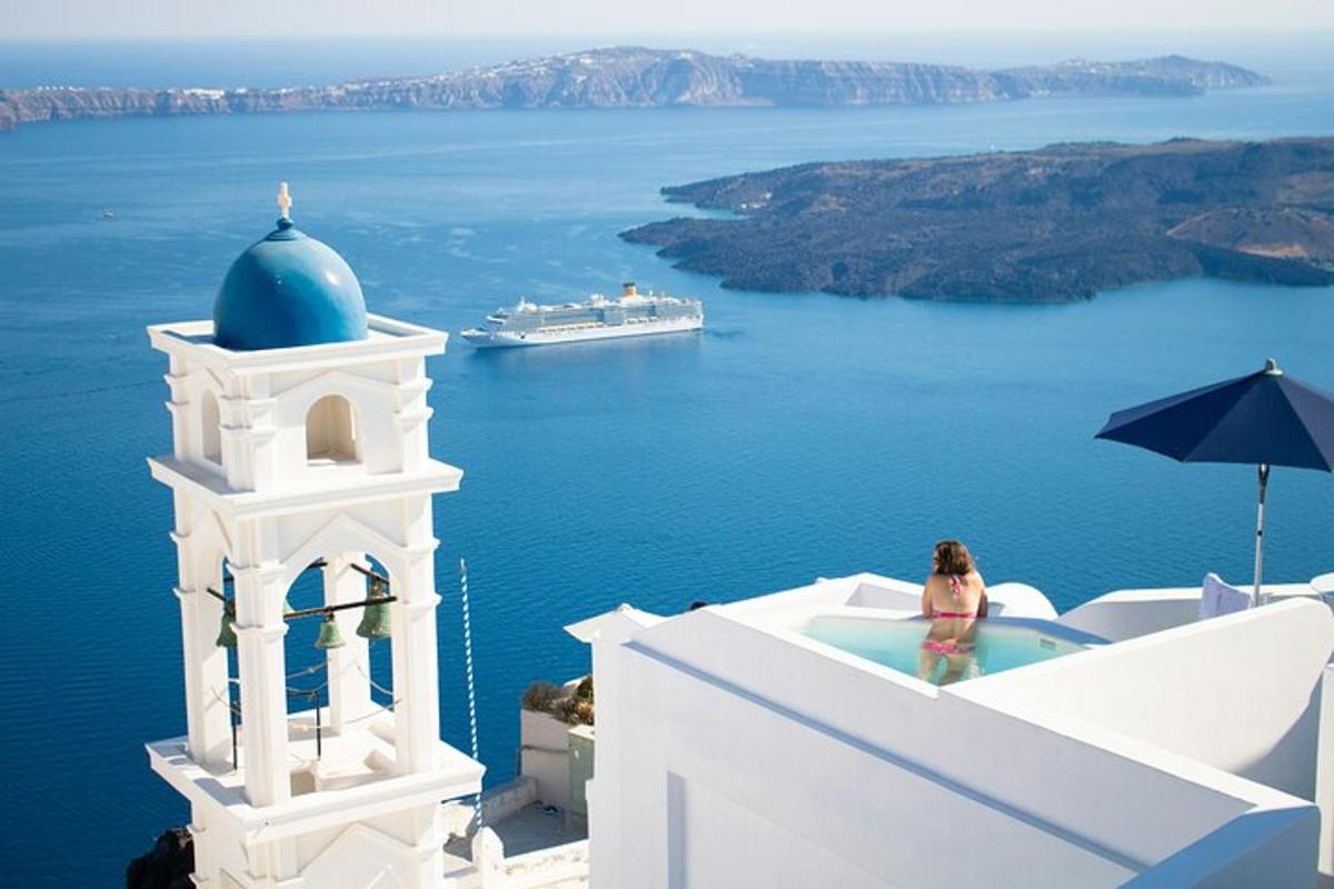 una donna in una vasca da bagno sul lato di un edificio con vista sull'oceano