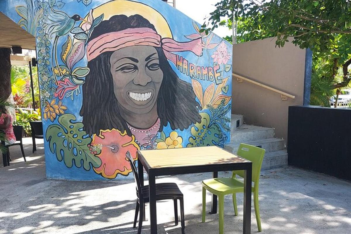 a table and chairs in front of a mural