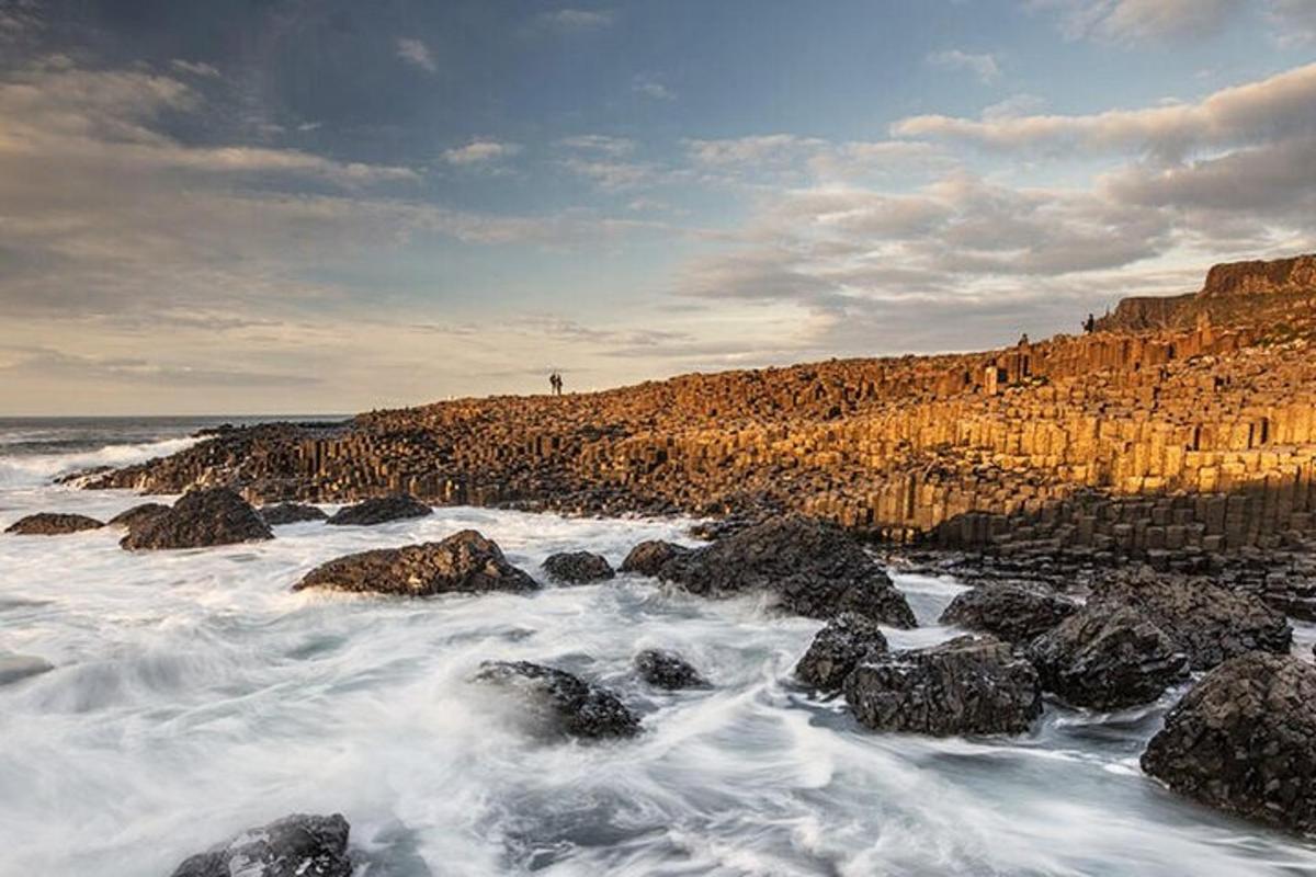 a beach with rocks and the ocean with waves