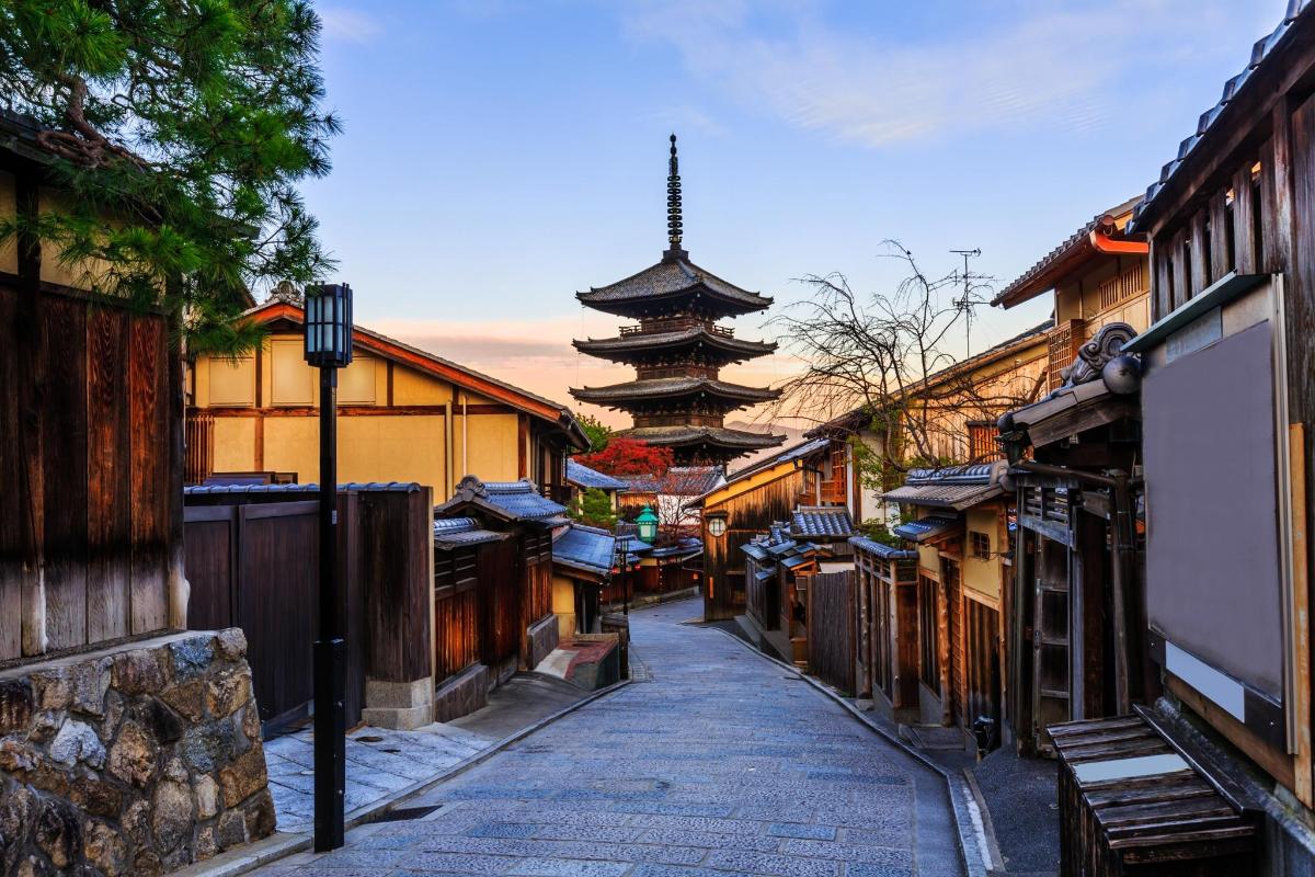 a narrow alley with a pagoda in the distance