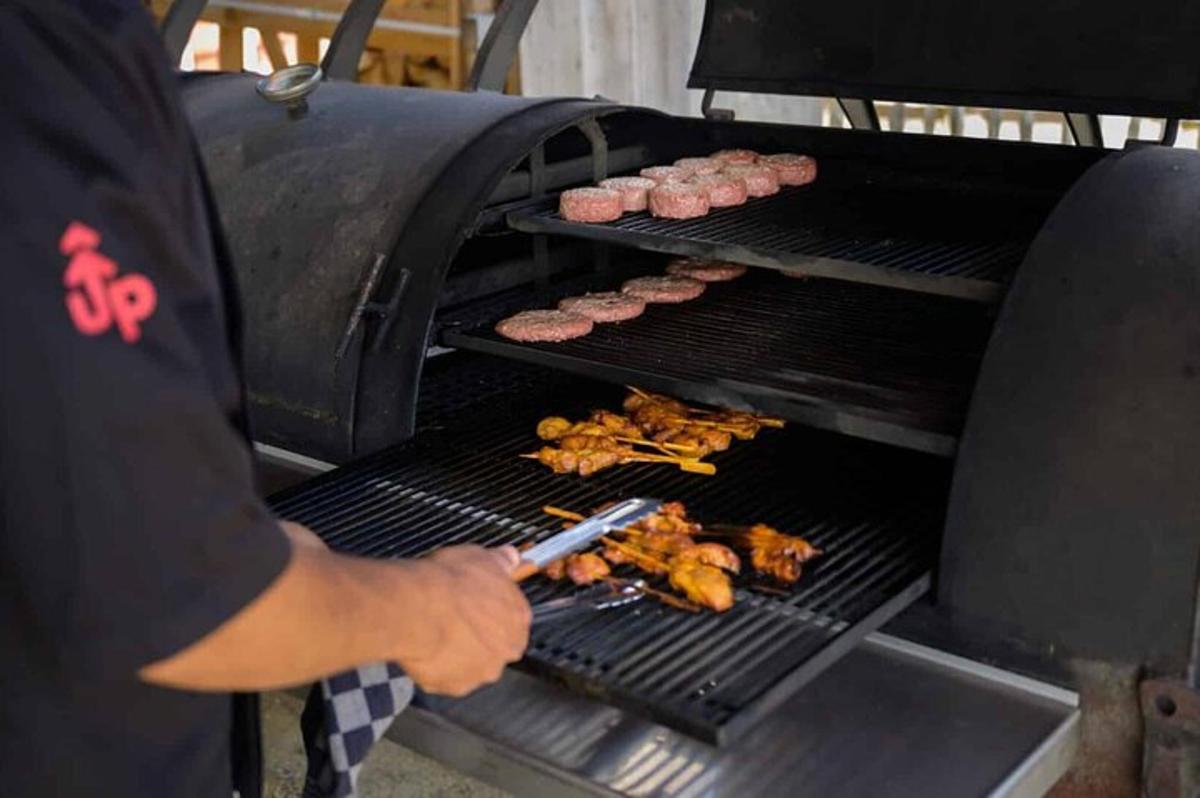 en mann lager mat på en grill