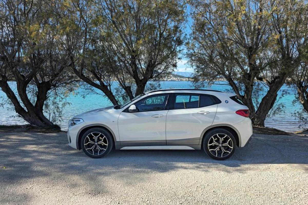 bílé auto zaparkované vedle vodní plochy