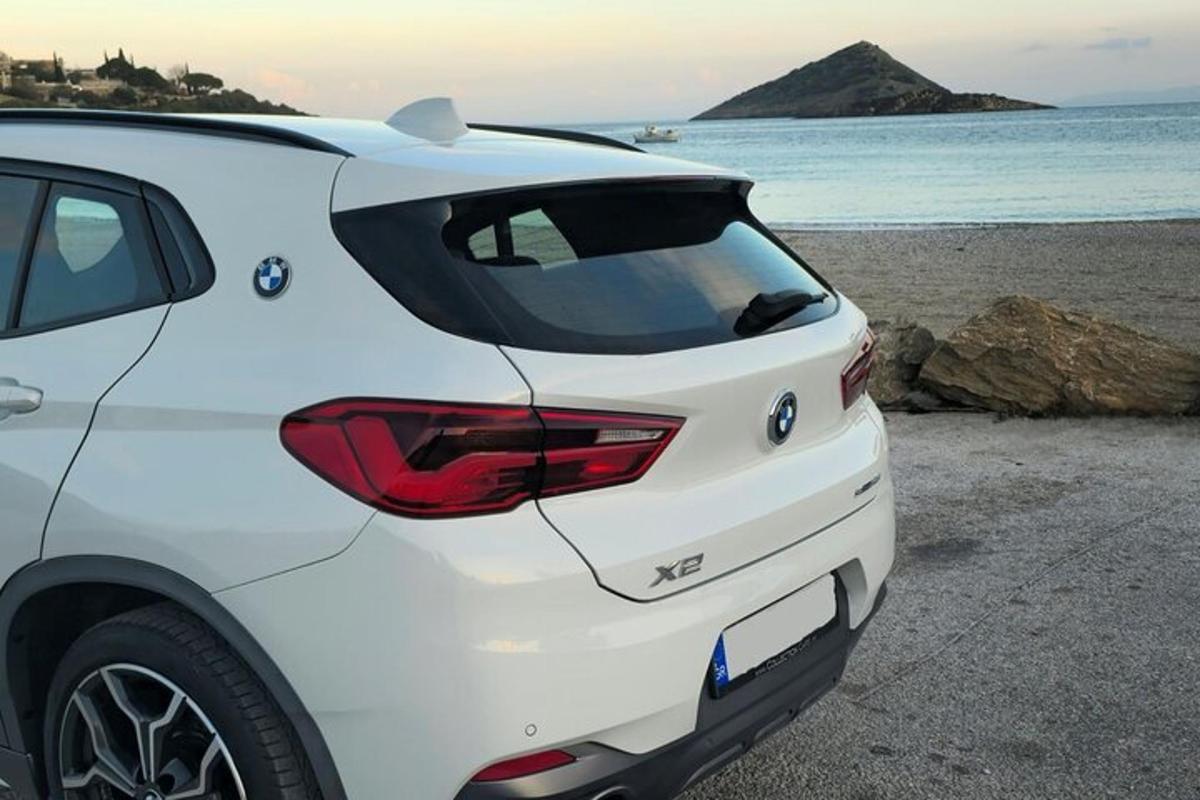 bílé auto zaparkované na pláži u oceánu