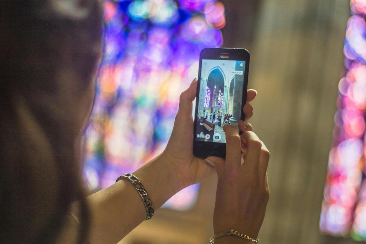 seorang wanita mengambil gambar dengan telefon bimbitnya