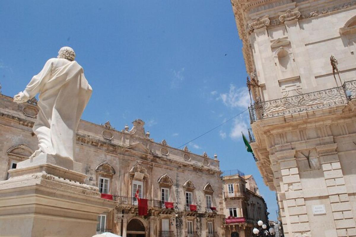 una statua di un uomo in piedi davanti a un edificio