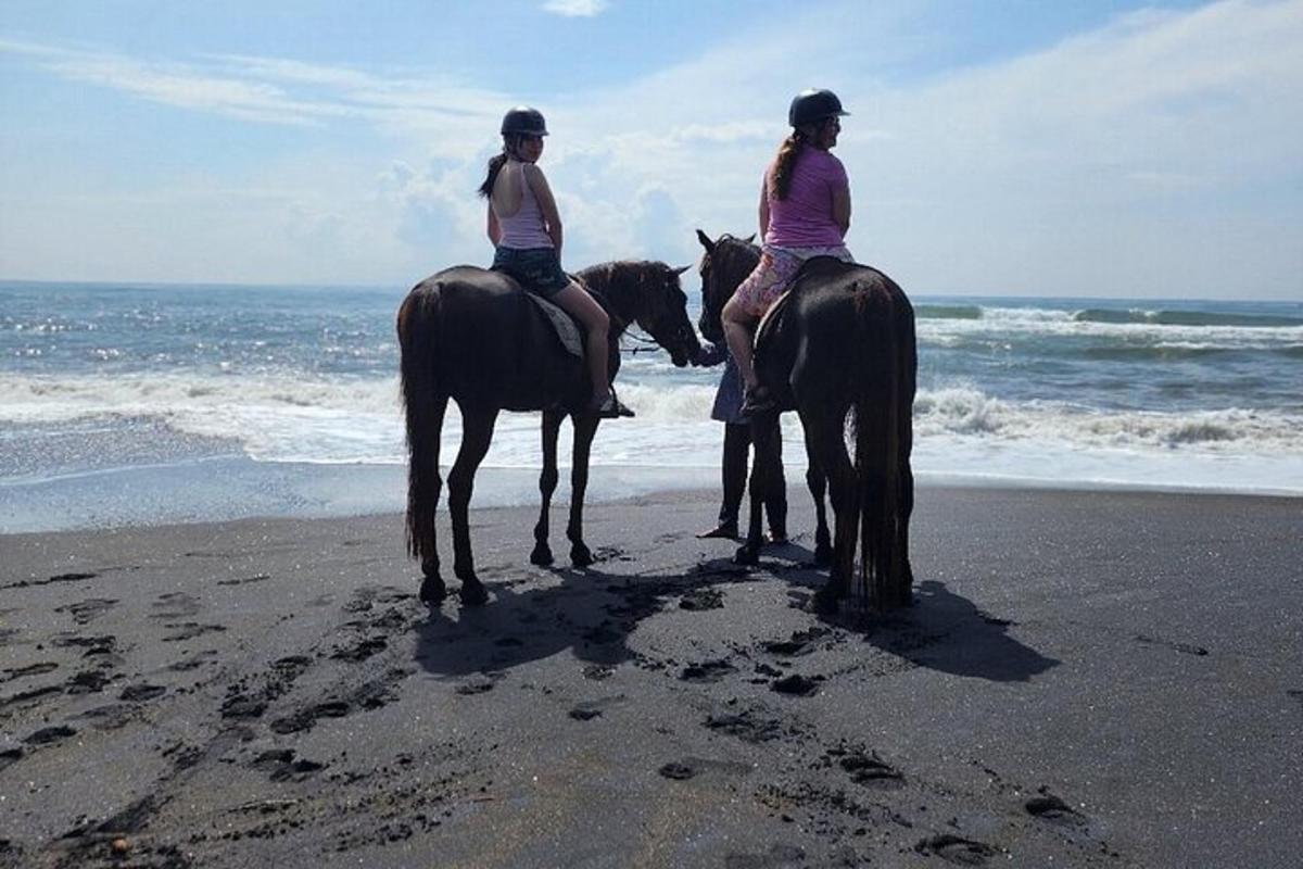 due donne stanno cavalcando sulla spiaggia