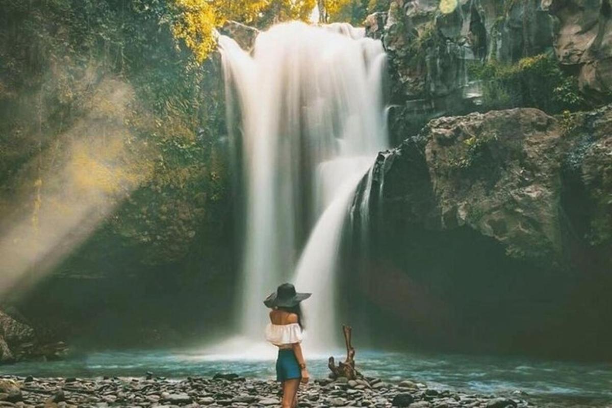 una mujer parada frente a una cascada