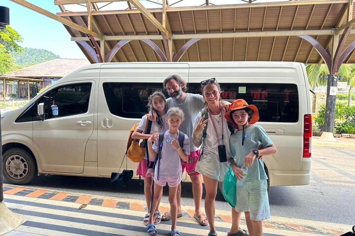 a family posing for a picture in front of a van