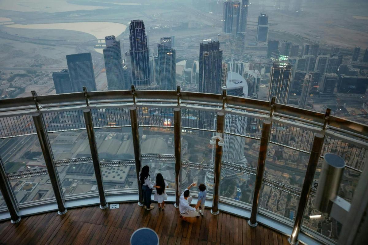 a group of people standing on the edge of the observation deck at the observation deck