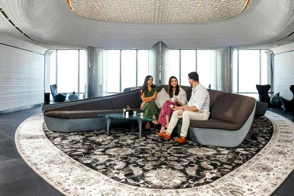 three people sitting on a couch in a living room