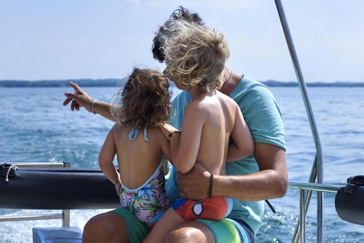 a man and two little girls sitting on a boat