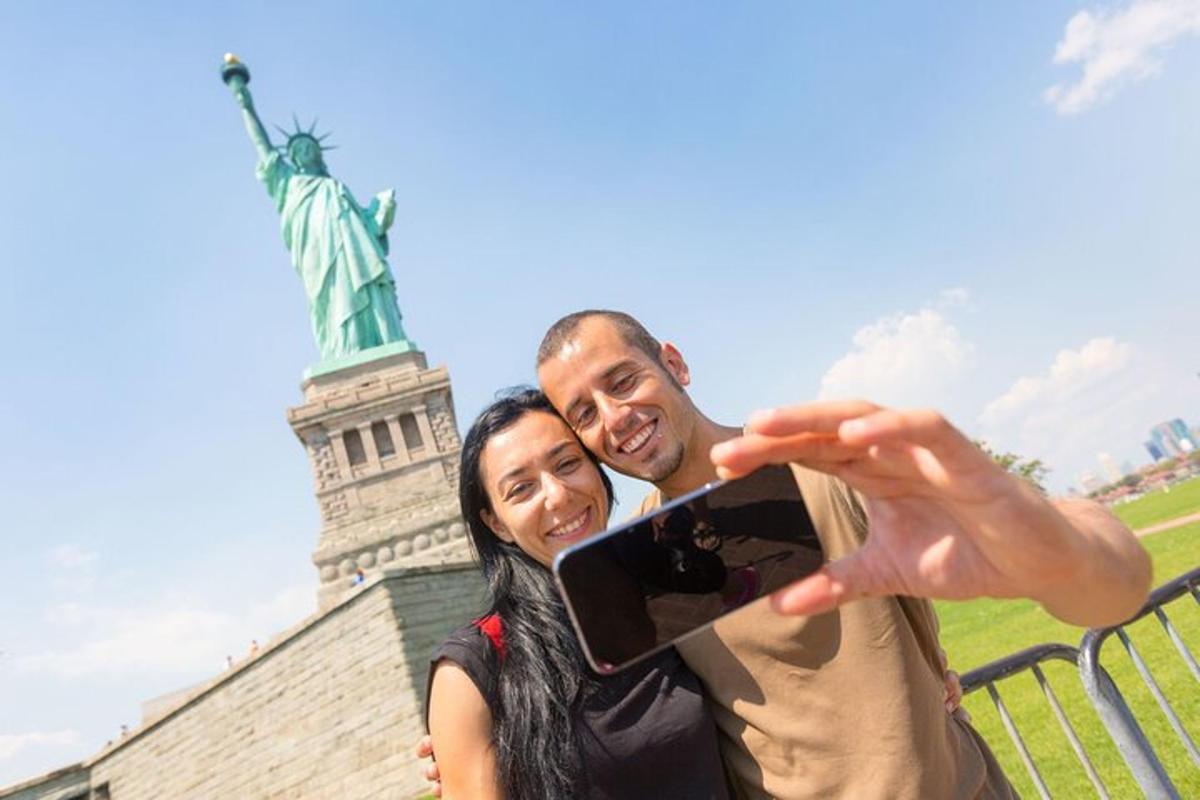 um homem e uma mulher tirando uma foto em frente à estátua da liberdade