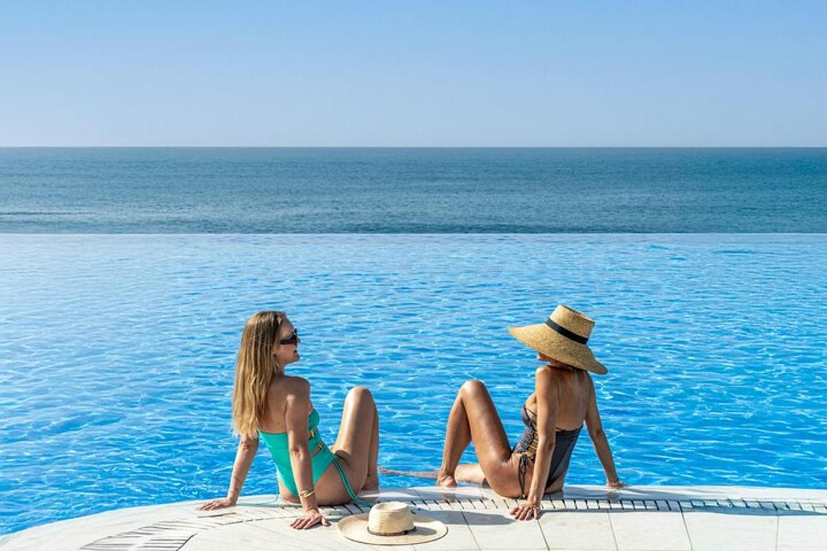 due donne sedute sul bordo di una piscina