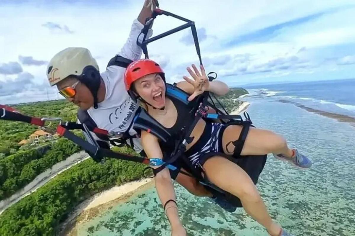 two people are riding on a zip line over the water