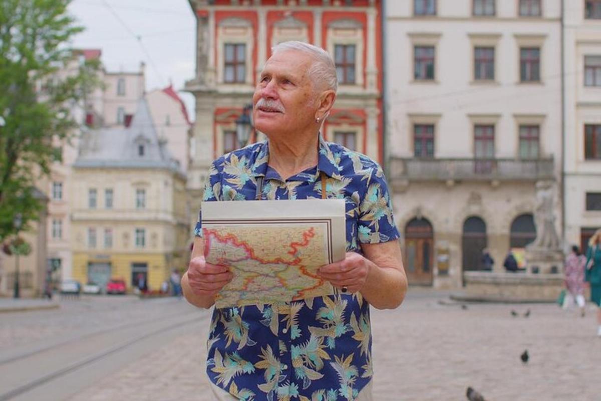 Starší muž držící puzzle před ulicí