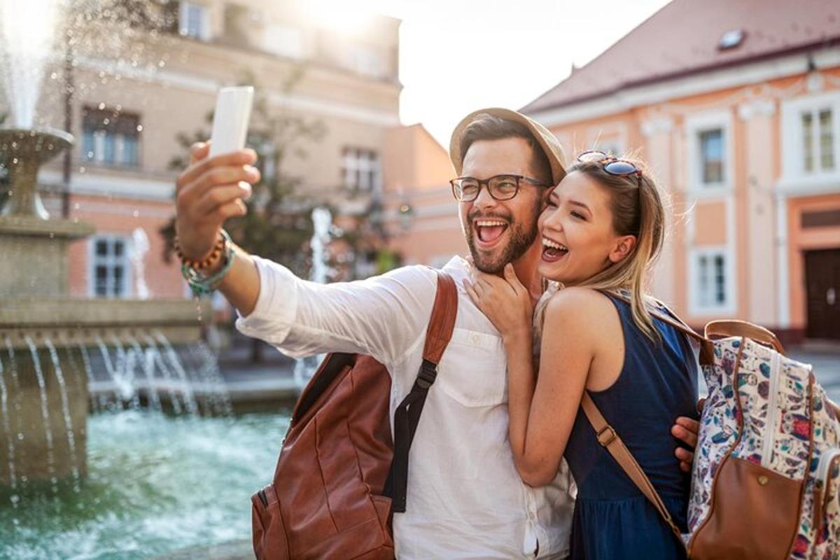 un uomo e una donna che scattano una foto di una fontana