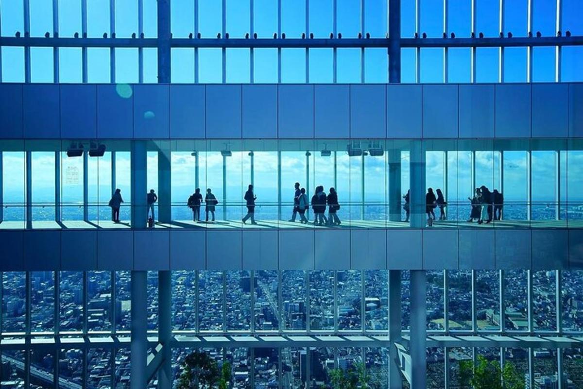 people walking on the glass floor of a building
