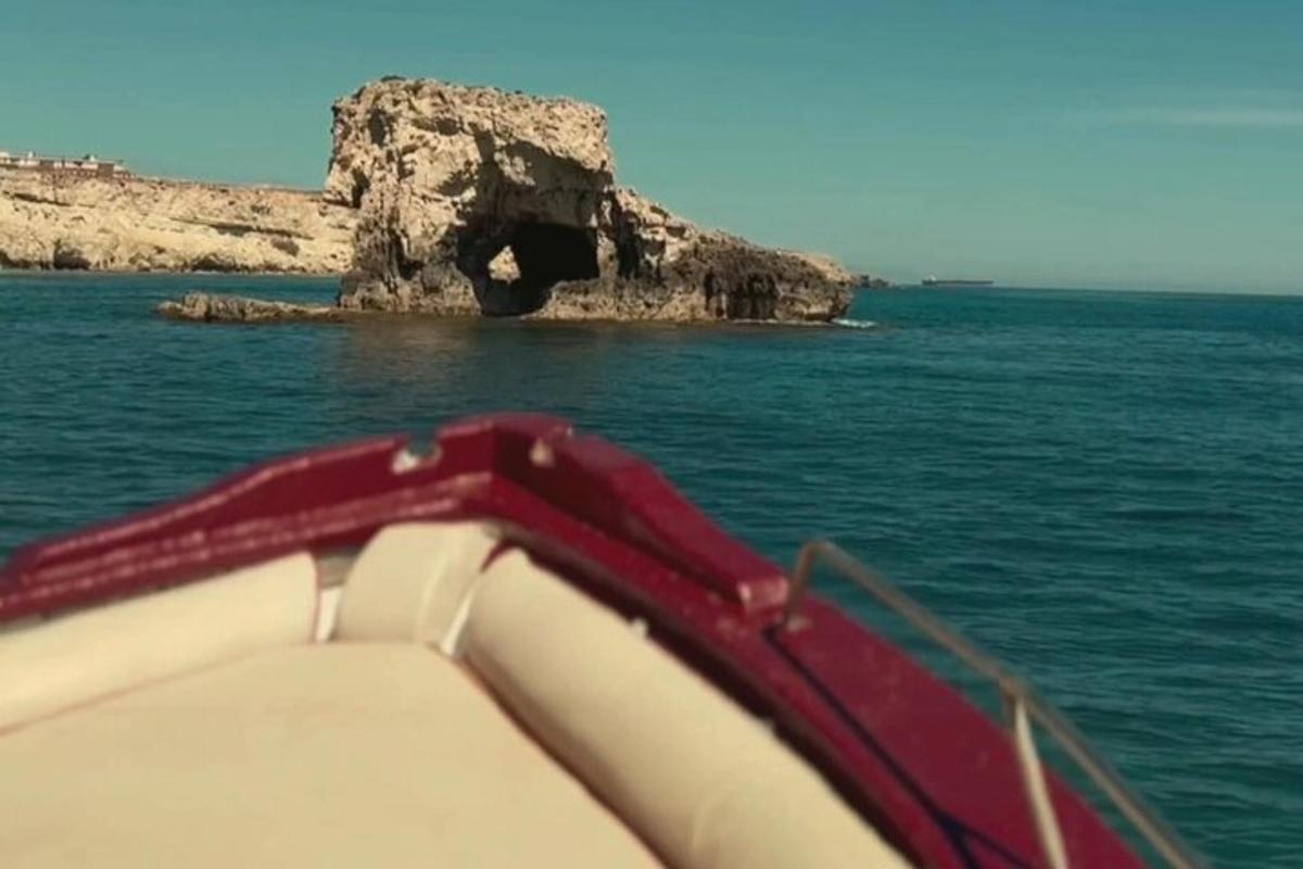 čoln v oceanu s skalo v vodi