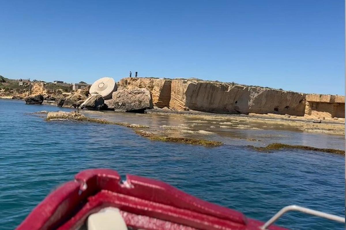 egy piros hajó a vízben a strand mellett