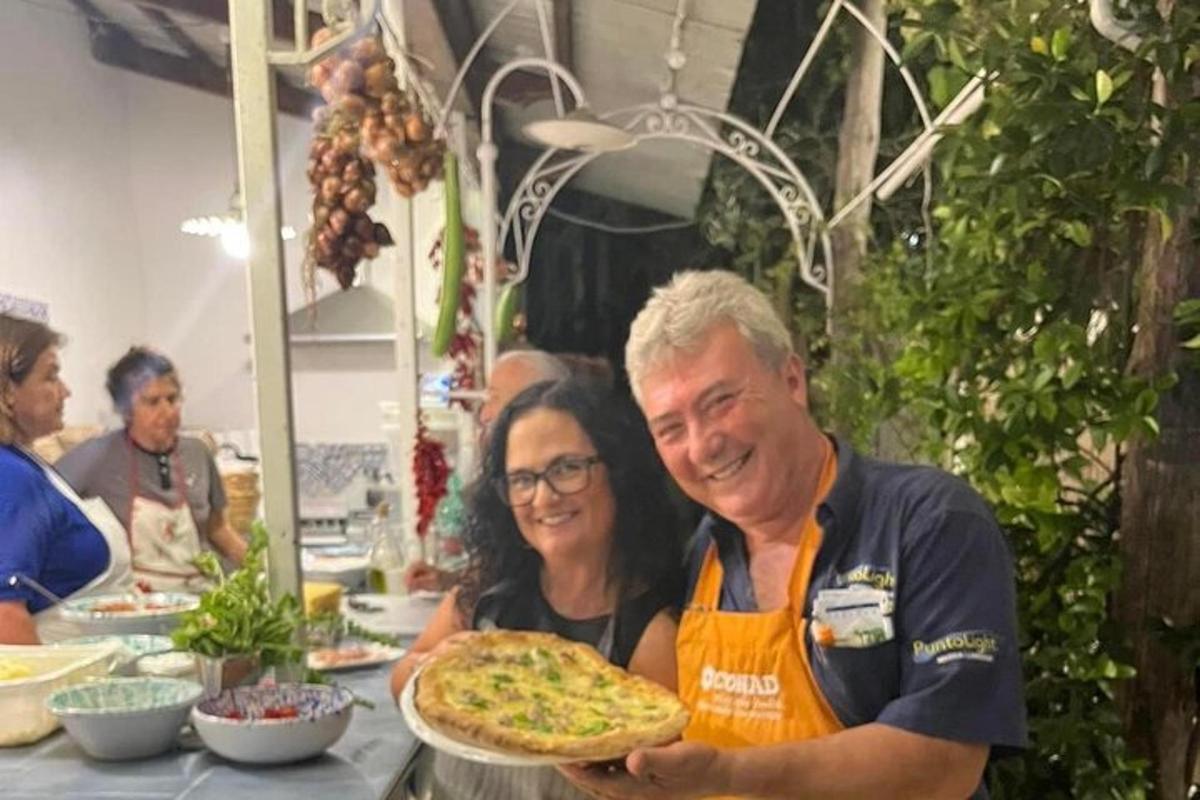 a man and a woman holding a pizza