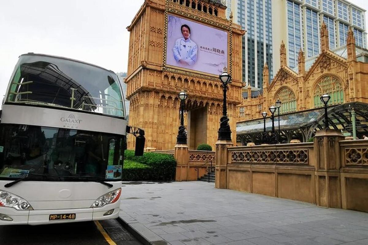 un autobus a due piani parcheggiato davanti a una torre dell'orologio