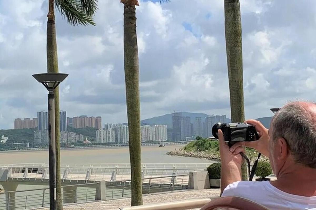 un uomo che scatta una foto di un fiume con una macchina fotografica