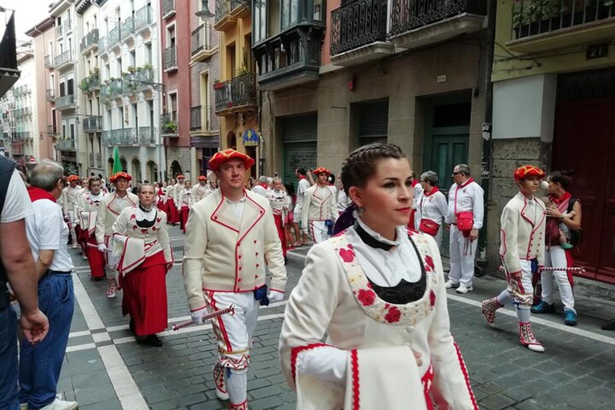 a group of people dressed in red and white walking down a street