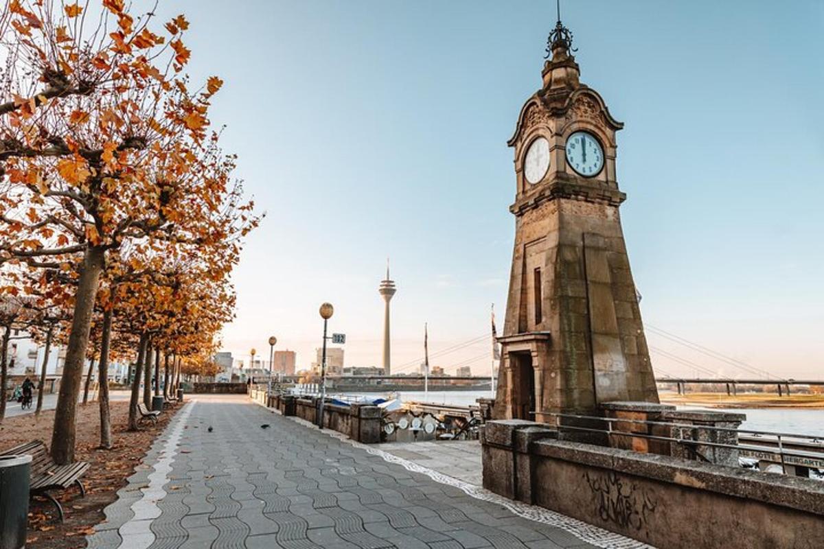 una torre dell'orologio situata accanto a un fiume con un ponte