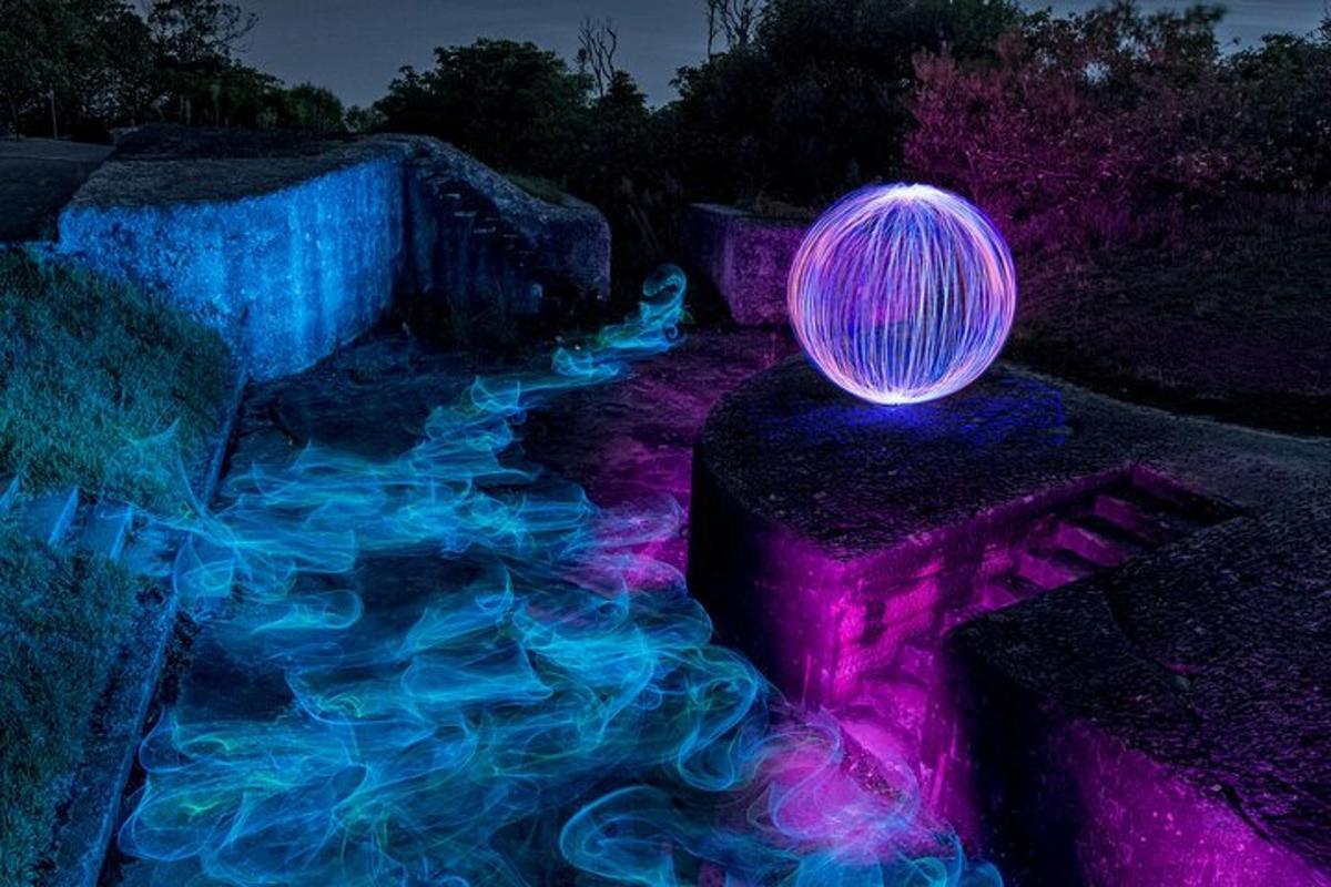 un globo illuminato viola e blu seduto su una roccia